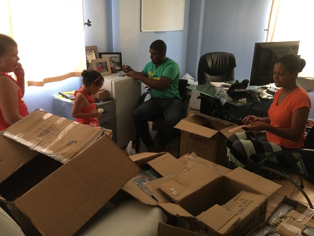 Fibernetics call centre employees volunteer to unpack and sort school supplies (with some help from Peter's daughters!)
